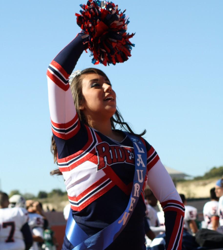 Lauren Macias, senior, cheers on the Riders at a football game this season, practicing her skills for Nationals the following semester. Photo by Andrea Logan