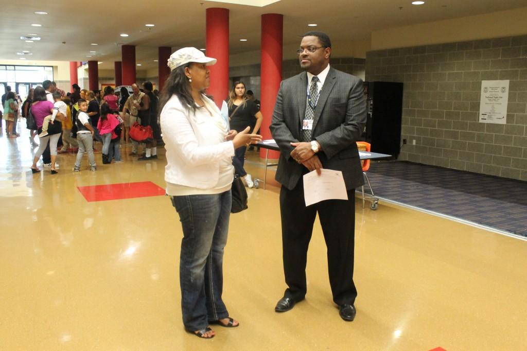 Principal Melvin Echard visits with a parent on Rough Rider 1st Floor.
