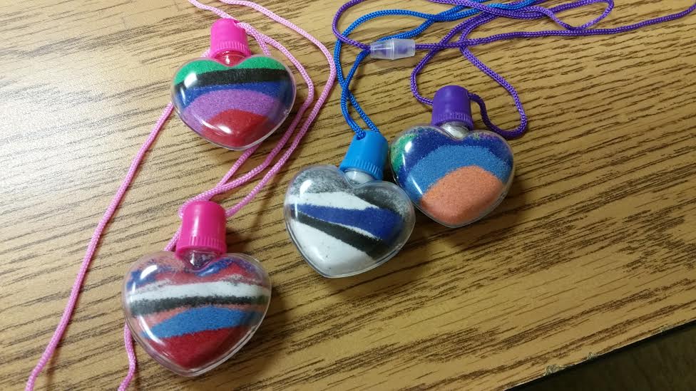 Students sand art hearts.