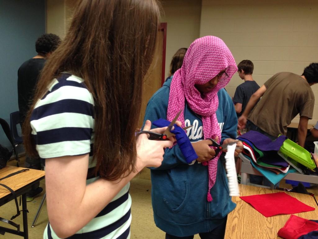 In C lunch, two  freshmen students make their moms a corsage.
