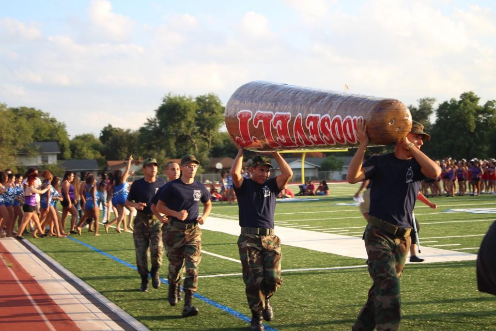 From right to left JROTC students, Enrique Flores-Smith (Junior), Benjamin Montenegro (Sophomore), William Smith (Sophomore), Alex Marsh (Junior) and David Rodriguez (Sophomore)  march alongside the track