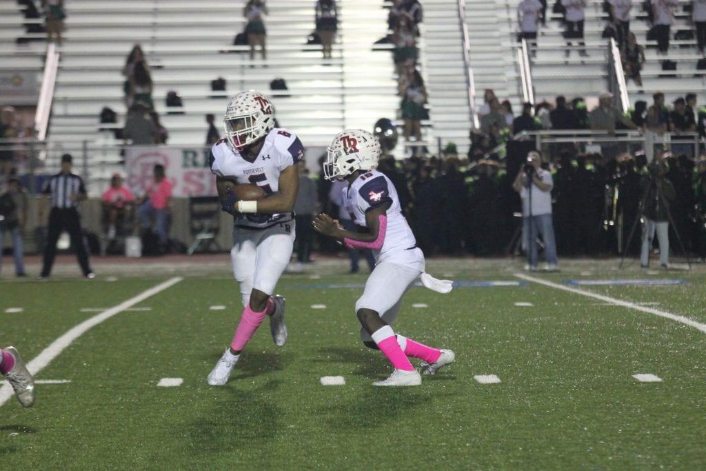 Senior Rashod Owens carries the ball in the Pink Out game against Reagan. The Riders won 28-21. Photo by Lizbeth Pereda