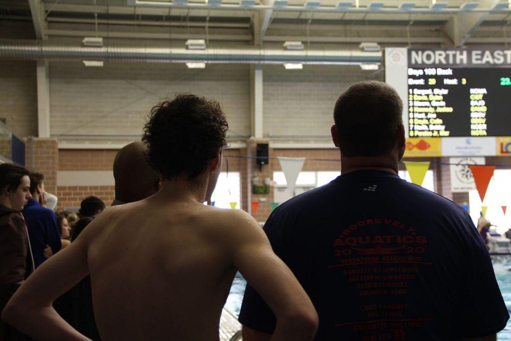 Senior Matthew Swanson and coach Willing talk after Swanson swam in preliminaries.